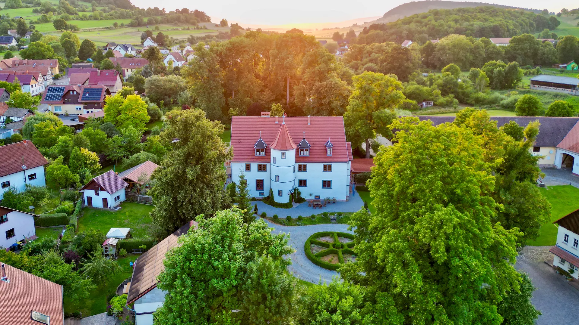 Luftbild von Schloß Roßdorf in Roßdorf mit Schlossgebäude, Parkanlage, Bäumen und umliegender Landschaft der Thüringischen Rhön