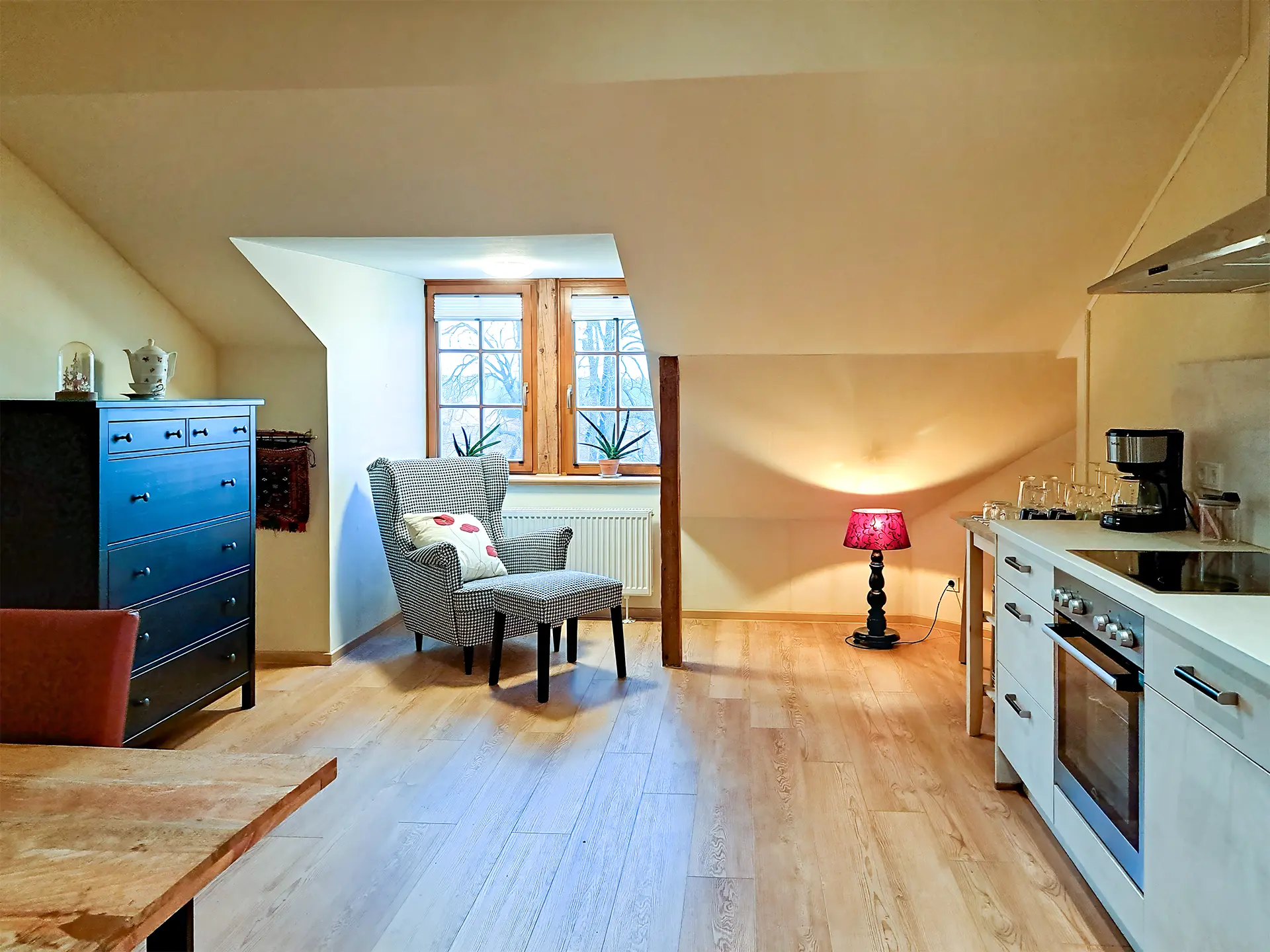 Heller Wohnbereich der Ferienwohnung von Berlepsch im Schloß Roßdorf mit Küchenzeile, Sessel und gemütlicher Ausstattung