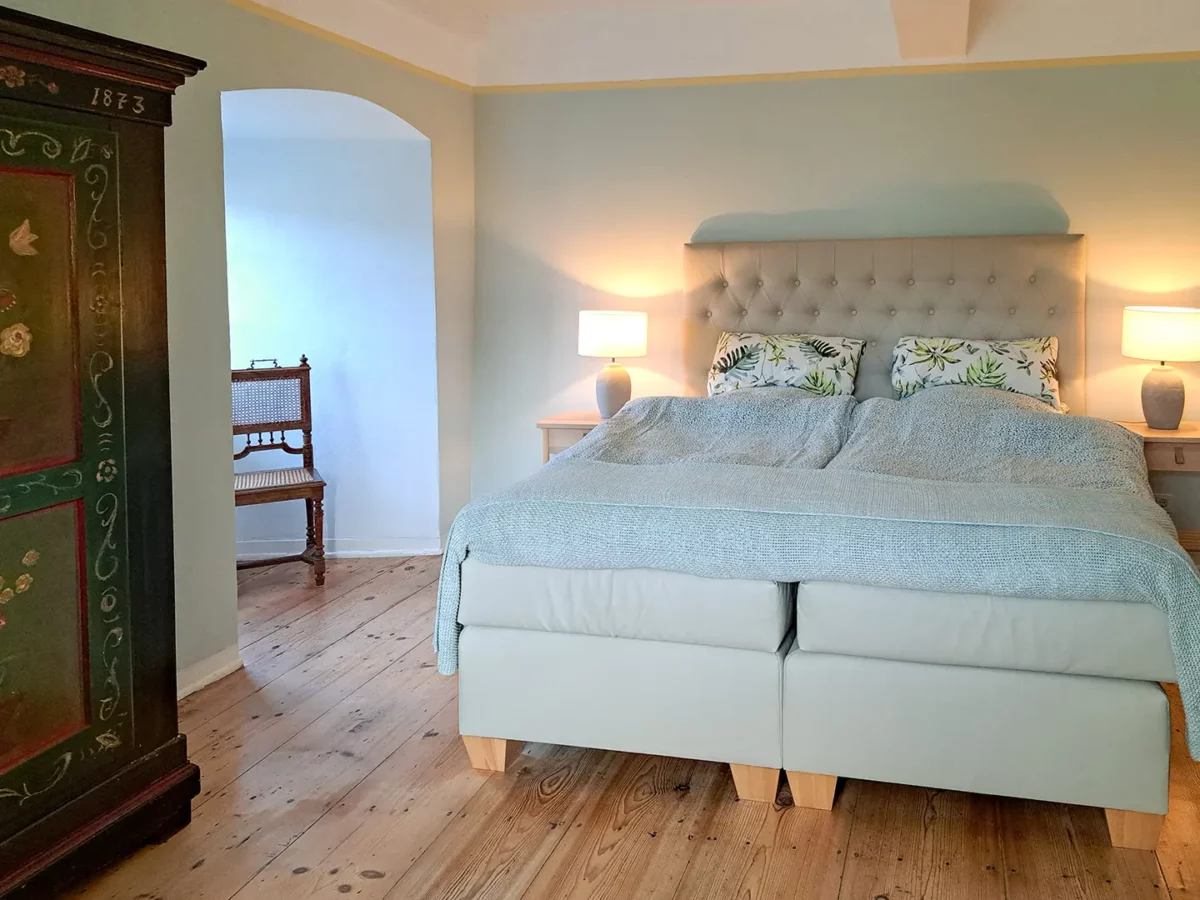 Stilvolles Schlafzimmer der Ferienwohnung von Henneberg im Schloß Roßdorf mit Doppelbett, Holzboden und historischer Einrichtung