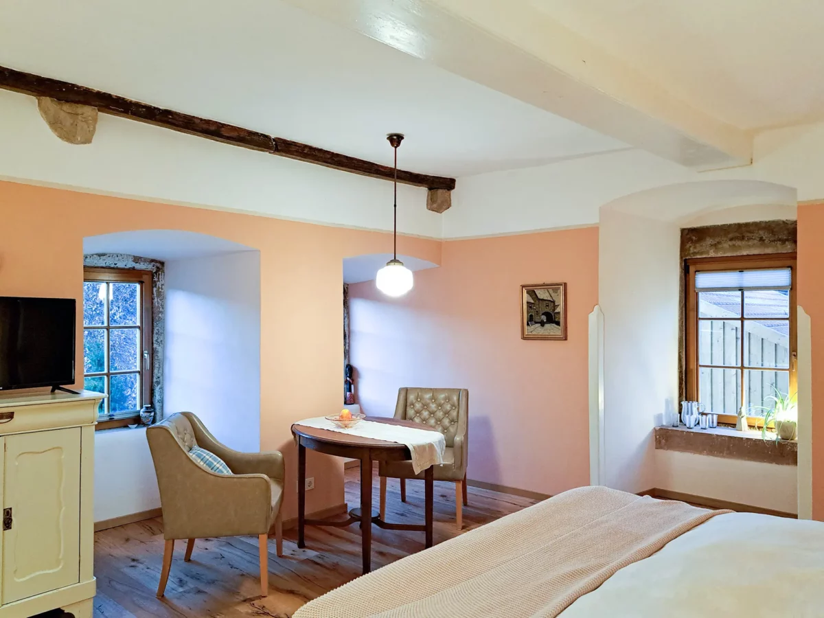 Gemütlicher Wohn- und Schlafbereich der Ferienwohnung von Roßdorf im Schloß Roßdorf mit Sitzplatz, historischen Fenstern und hellem Ambiente