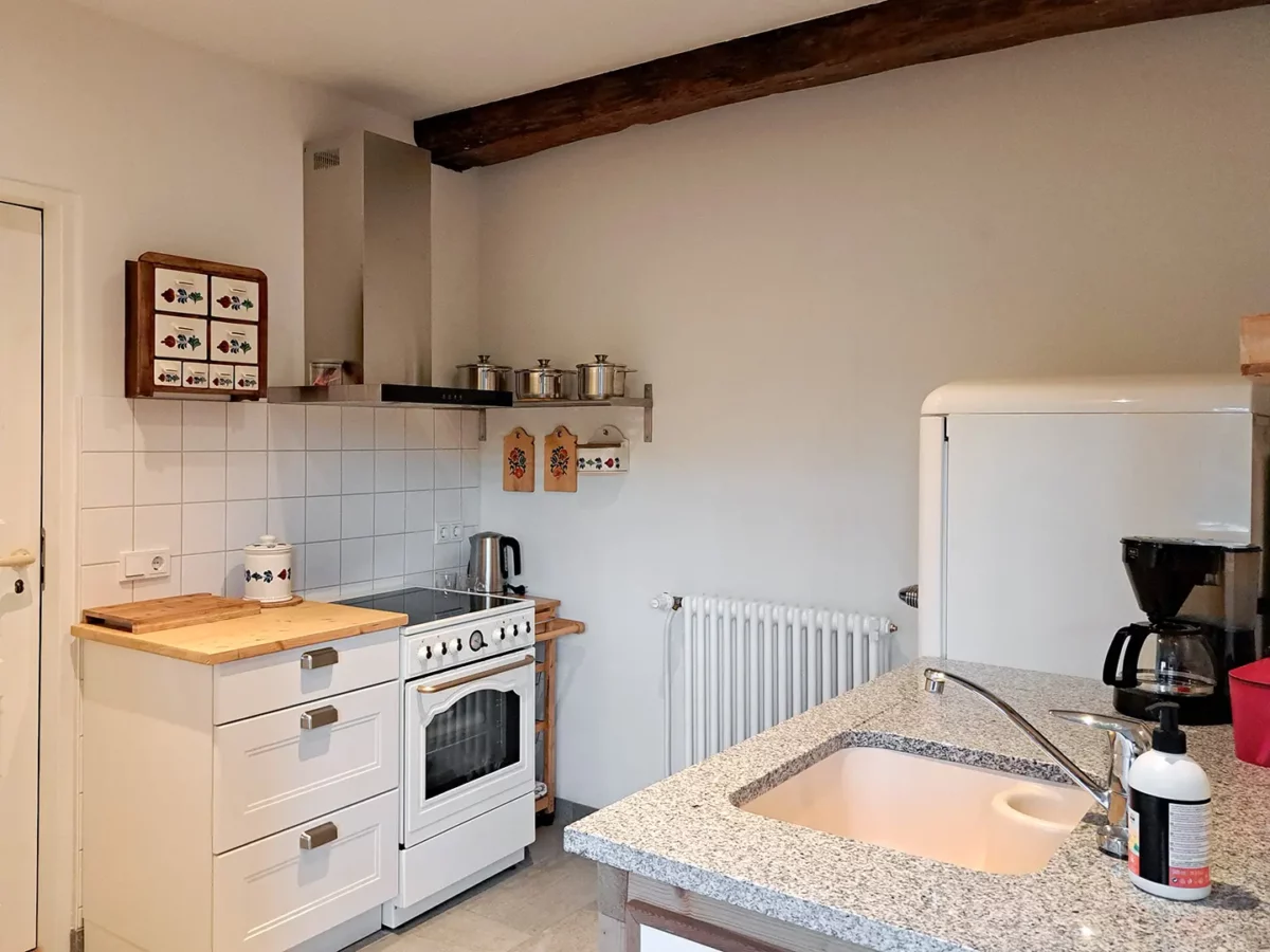 Küche der Ferienwohnung von Roßdorf im Schloß Roßdorf mit Kochbereich, Spüle, Kühlschrank und gemütlicher Ausstattung